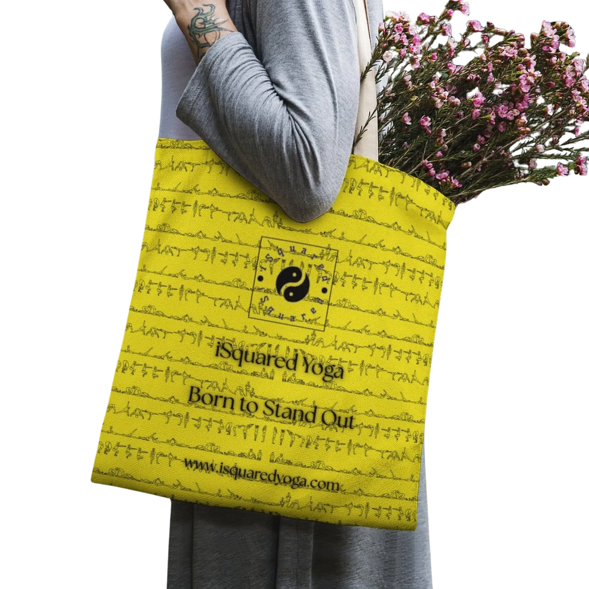 Yellow tote bag with black artistic print, worn on the shoulder, holding a bouquet of flowers.