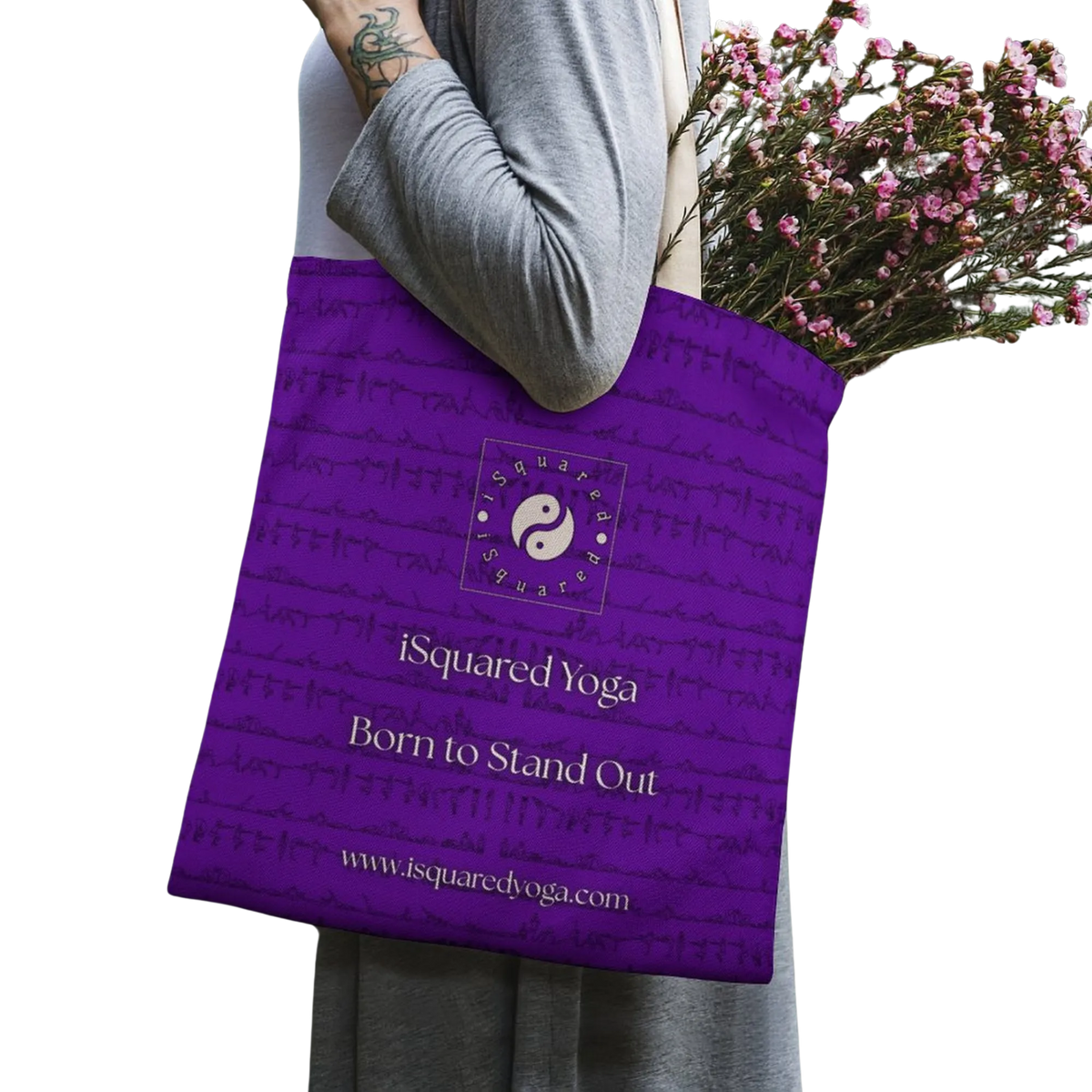 A purple iSquared Tote Bag featuring a yin-yang logo and the text "Born to Stand Out," filled with flowers.