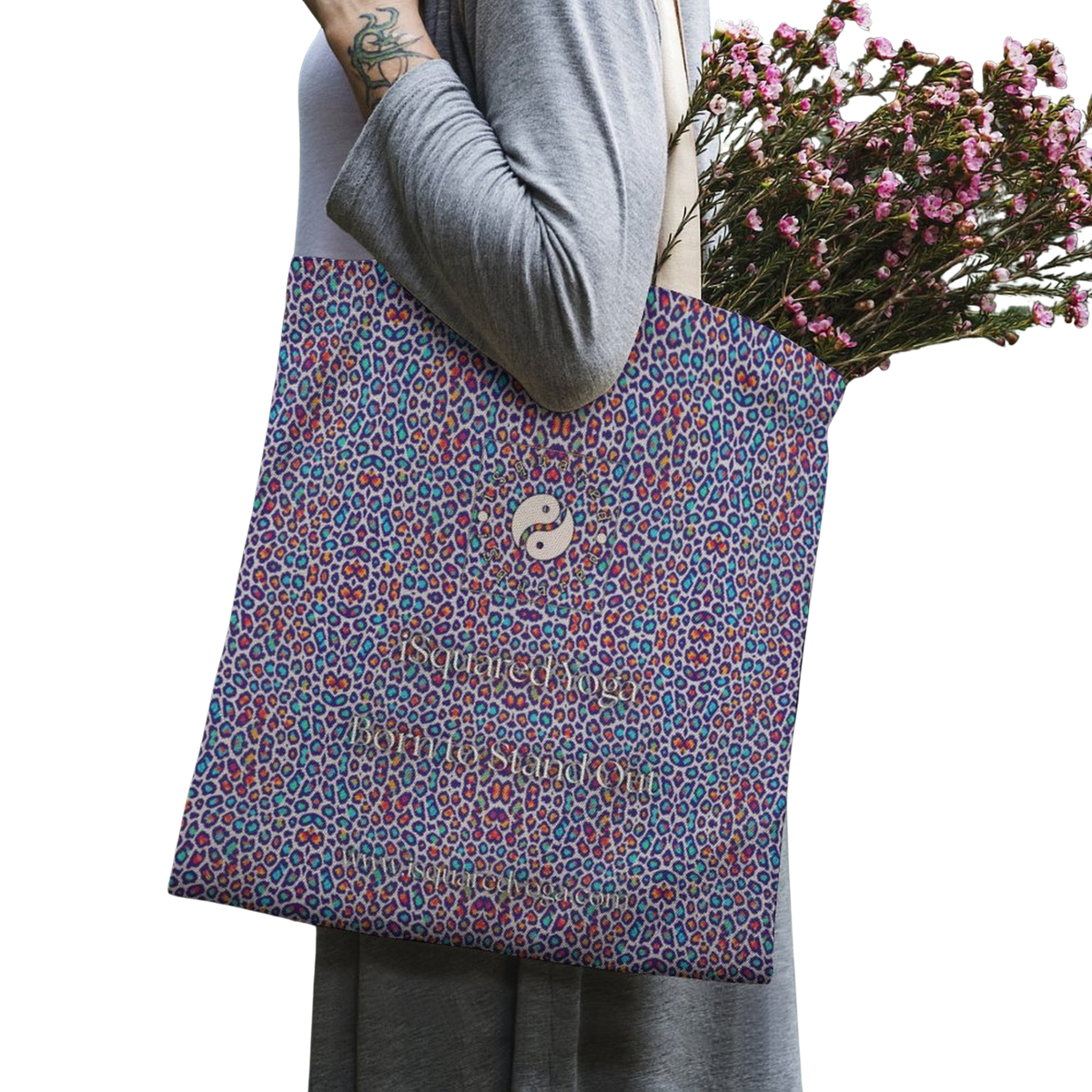 Tote bag featuring a vibrant purple and multi-colored wild leopard print, held by a model with flowers inside.