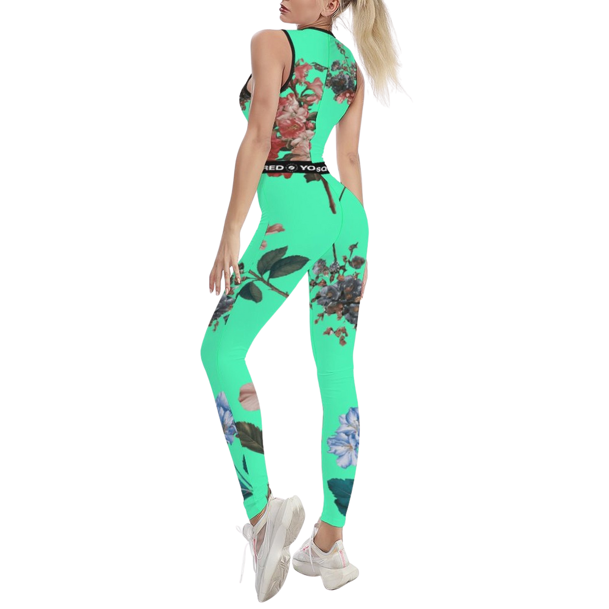 Sleeveless Botanicals iSquared Jumpsuit in vibrant green with floral patterns, worn fitted, paired with white sneakers.
