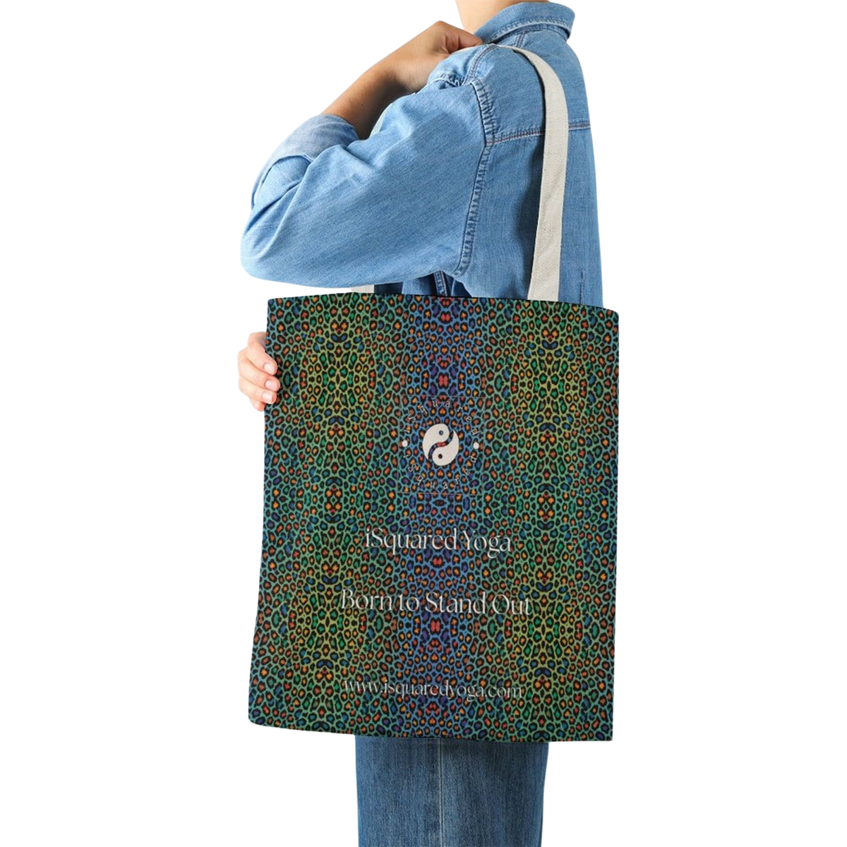 Colorful tote bag featuring a vibrant leopard print design in greens, blues, and accents of orange, held by a model.
