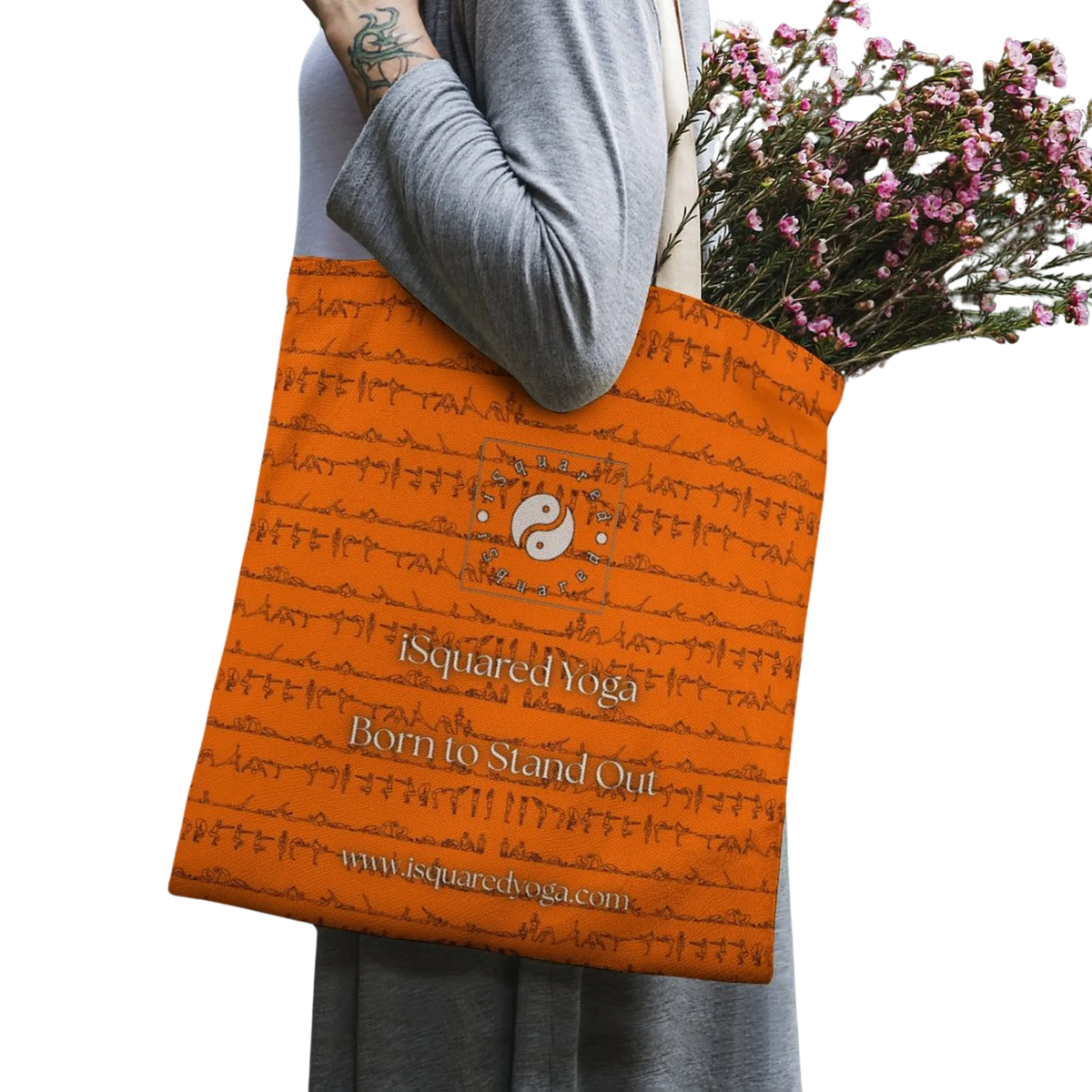 iSquared Tote Bag in bright orange features a yin-yang logo and yoga posture prints, held by a model with flowers.