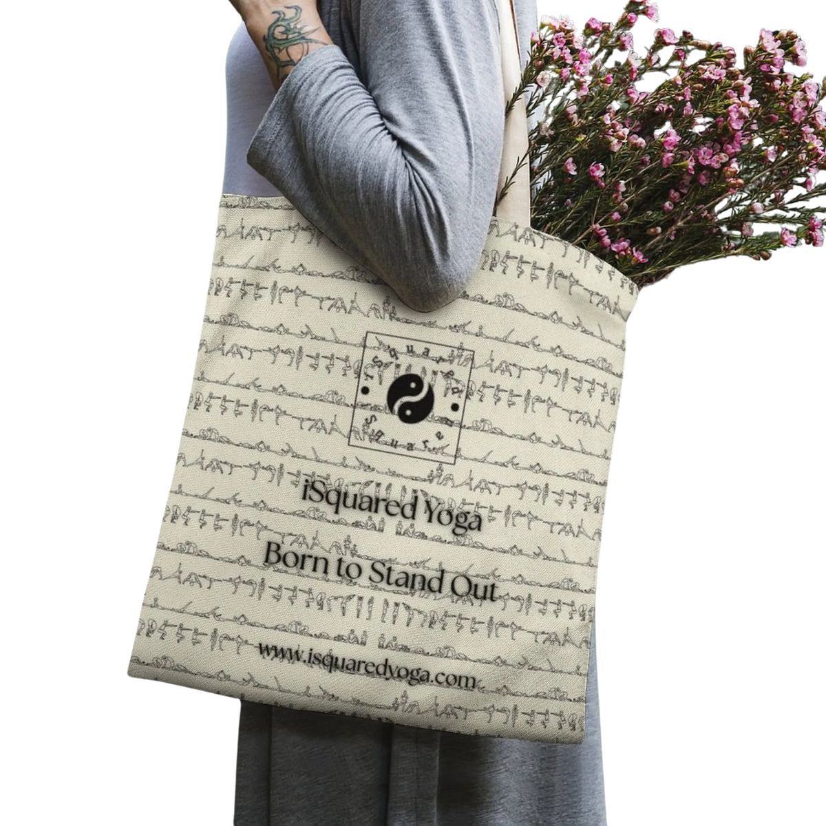Light beige tote bag featuring a unique black abstract print and logo, carried by a model with flowers inside.