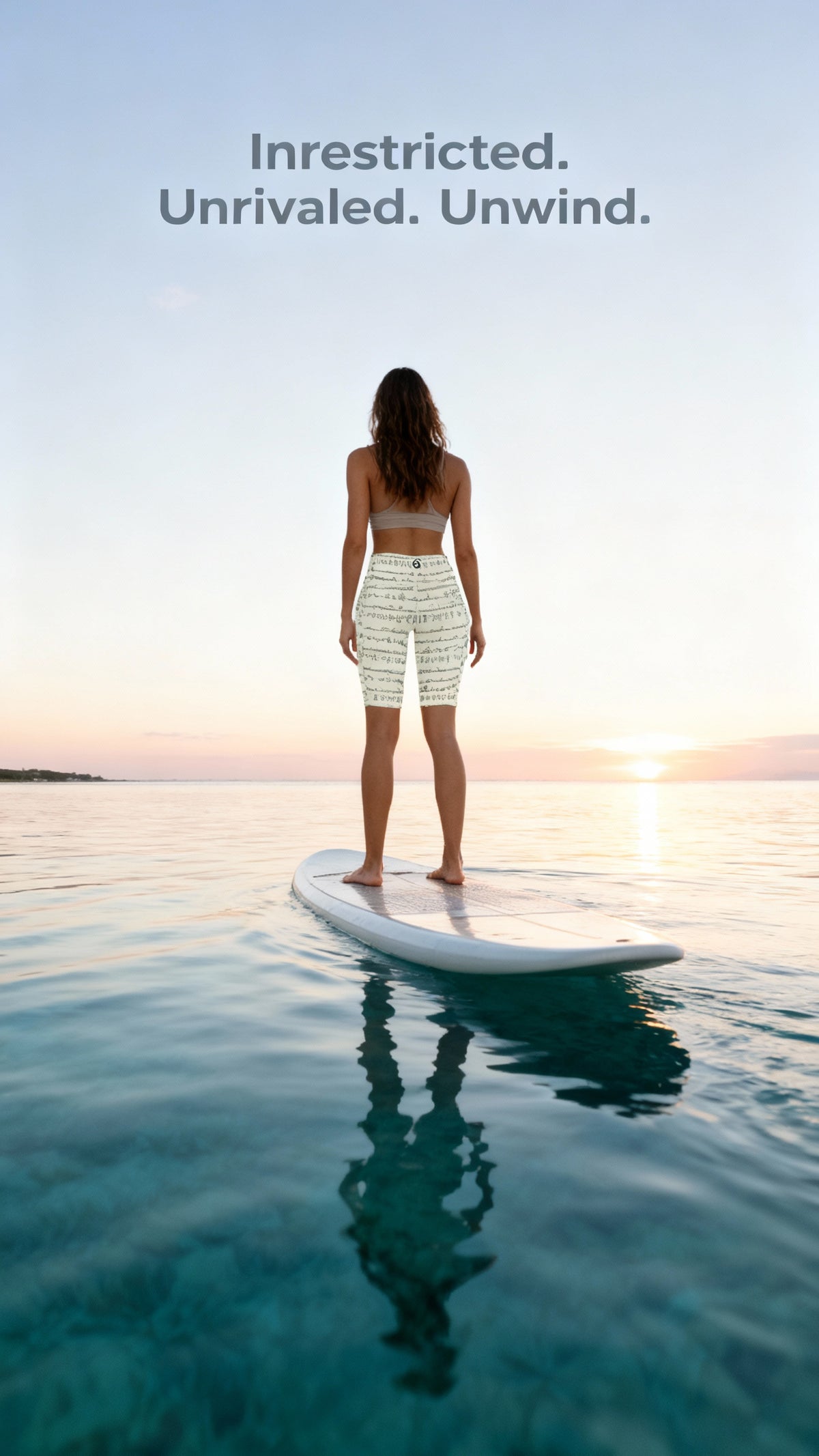 High-waisted iSquared Maureen Shorts in light color with a unique Bikram yoga print, worn by a model on a paddleboard.
