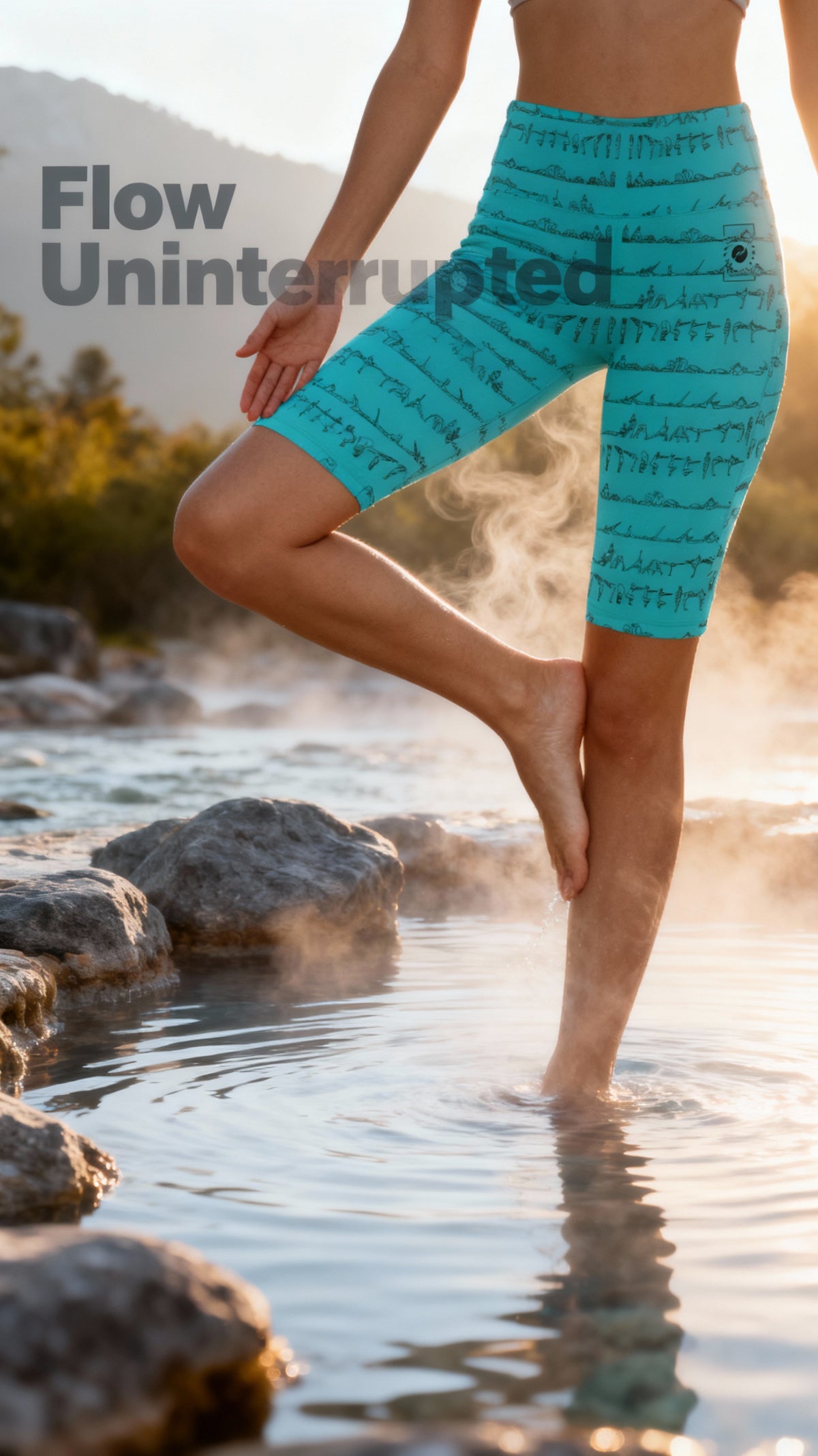 High-waisted turquoise biker shorts with a patterned print, worn by a model standing barefoot in shallow water.