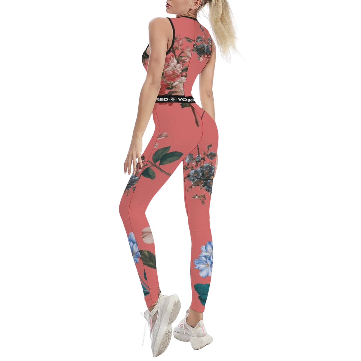 Sleeveless coral jumpsuit with floral print, featuring a body-contouring fit and worn with white sneakers.