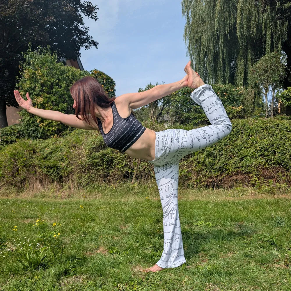 Cross-waisted flare leggings in cream with a subtle black pattern featuring yoga poses, designed for comfort and style.