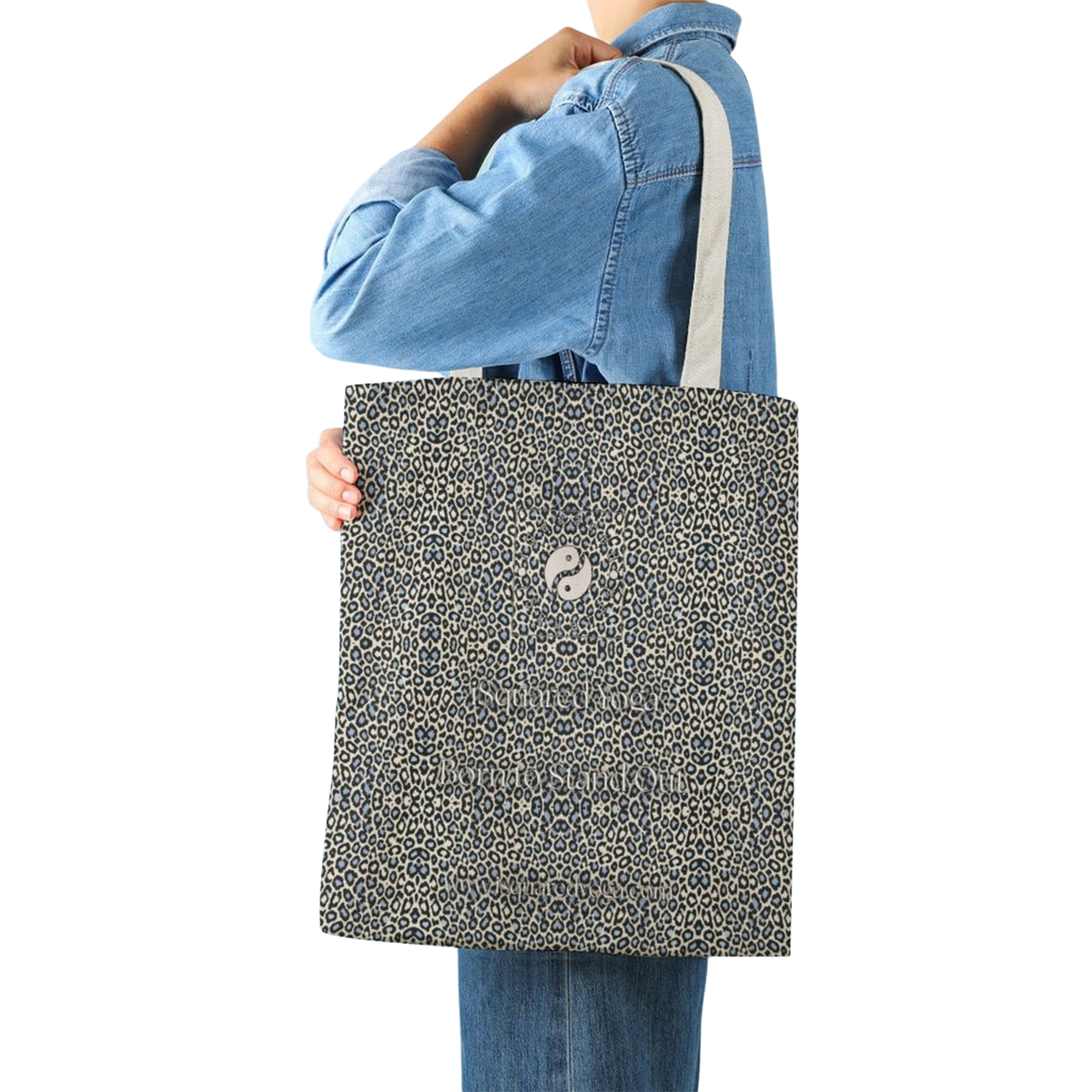 Tote bag featuring a classic leopard print in gold and black, held by a model wearing a denim shirt.