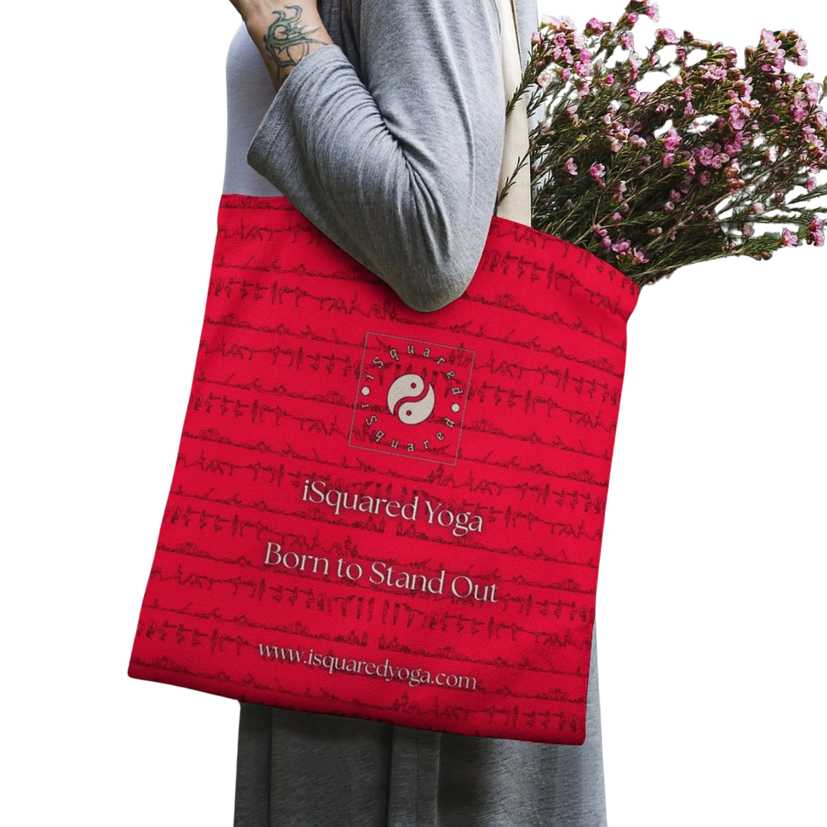 Red tote bag featuring a unique pattern and logo from iSquared Yoga, worn by a model with flowers inside.
