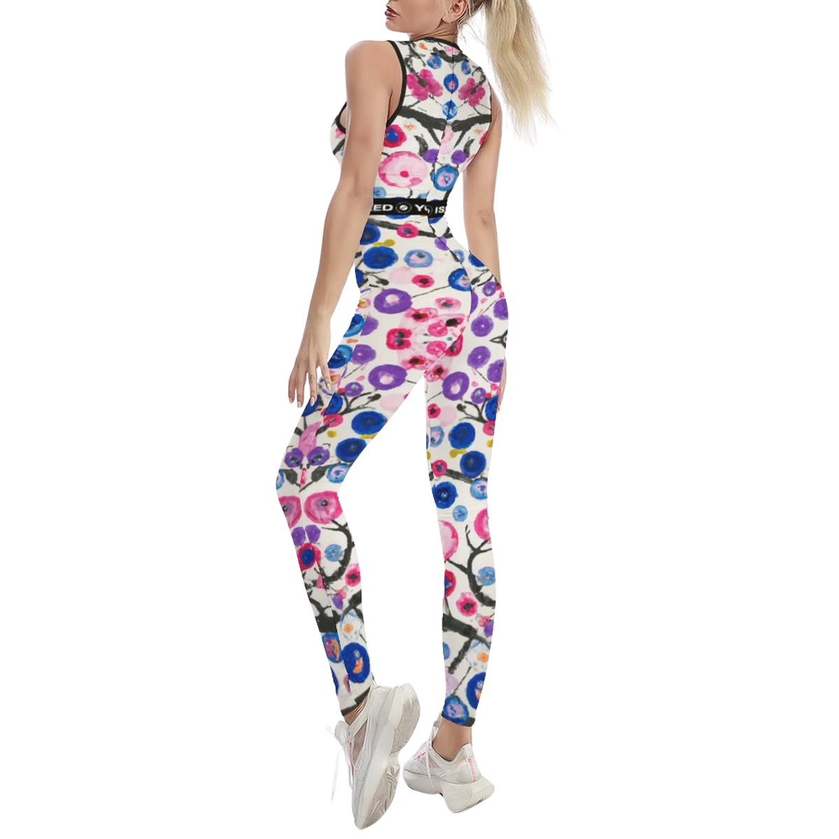 Sleeveless jumpsuit with a colorful floral pattern, body-contouring fit, and breathable fabric, paired with white sneakers.
