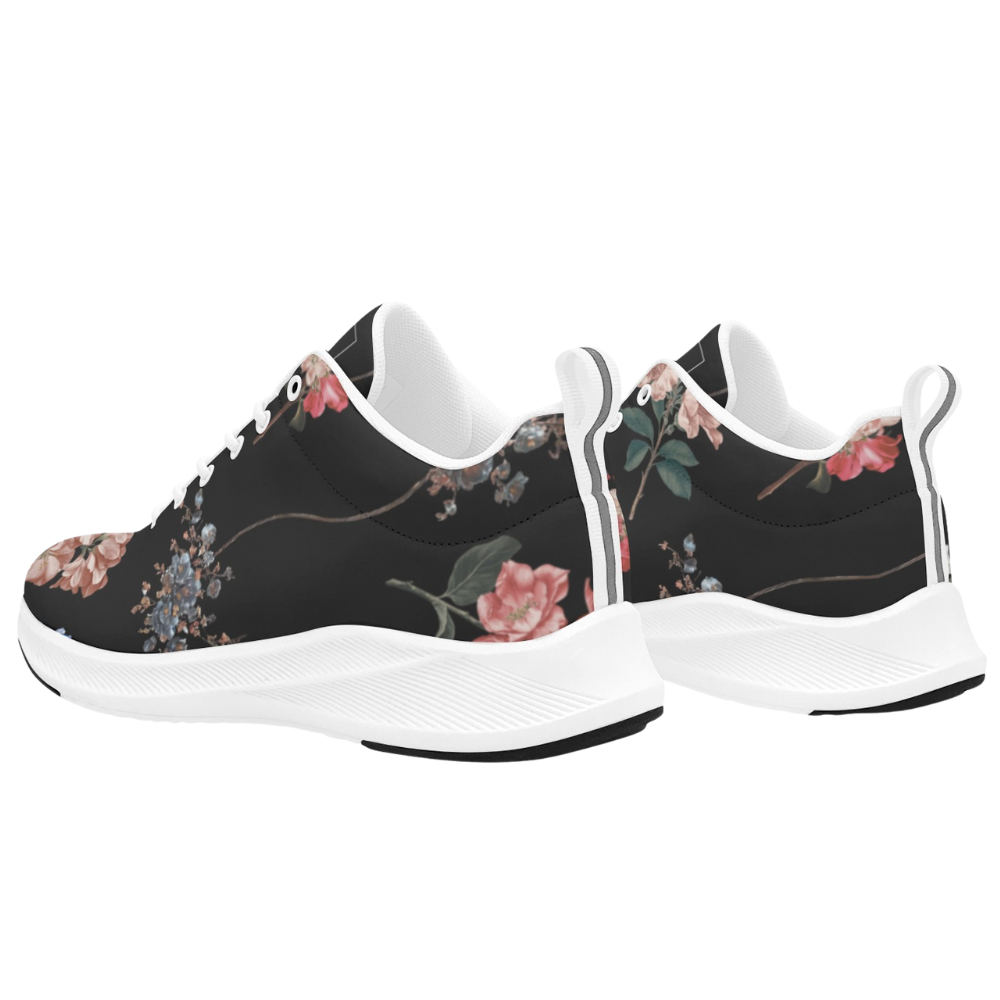 Black sneakers with floral patterns in pink and blue, featuring a white rubber sole and laces, designed for versatility.