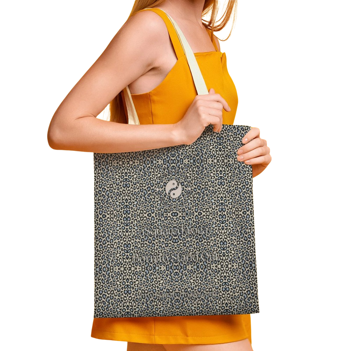 Tote bag featuring a wild leopard print in beige and navy, held by a model wearing a yellow dress.