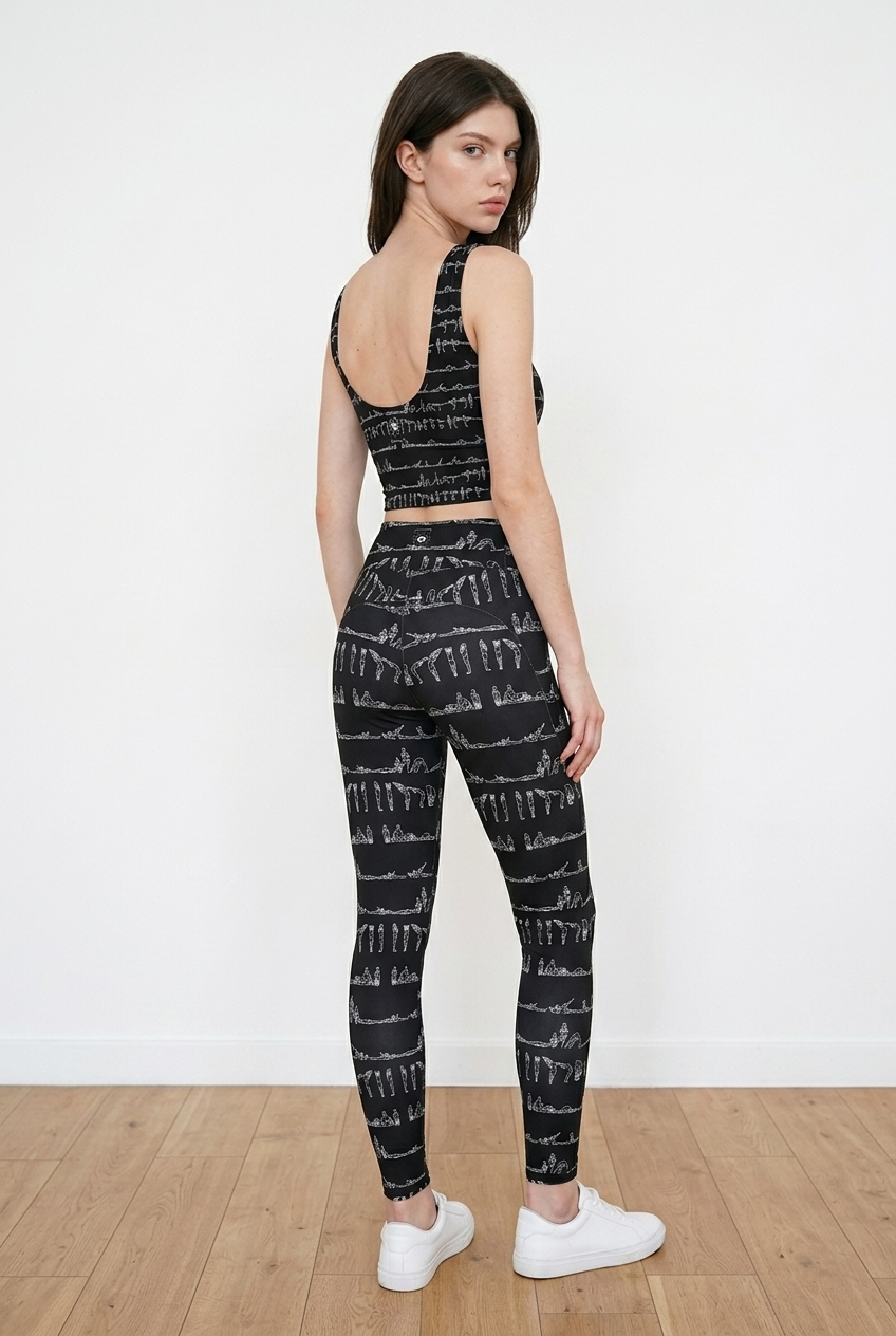 Bikram Ember pocket leggings in a black pattern with white detailing, worn with a matching crop top and white sneakers.