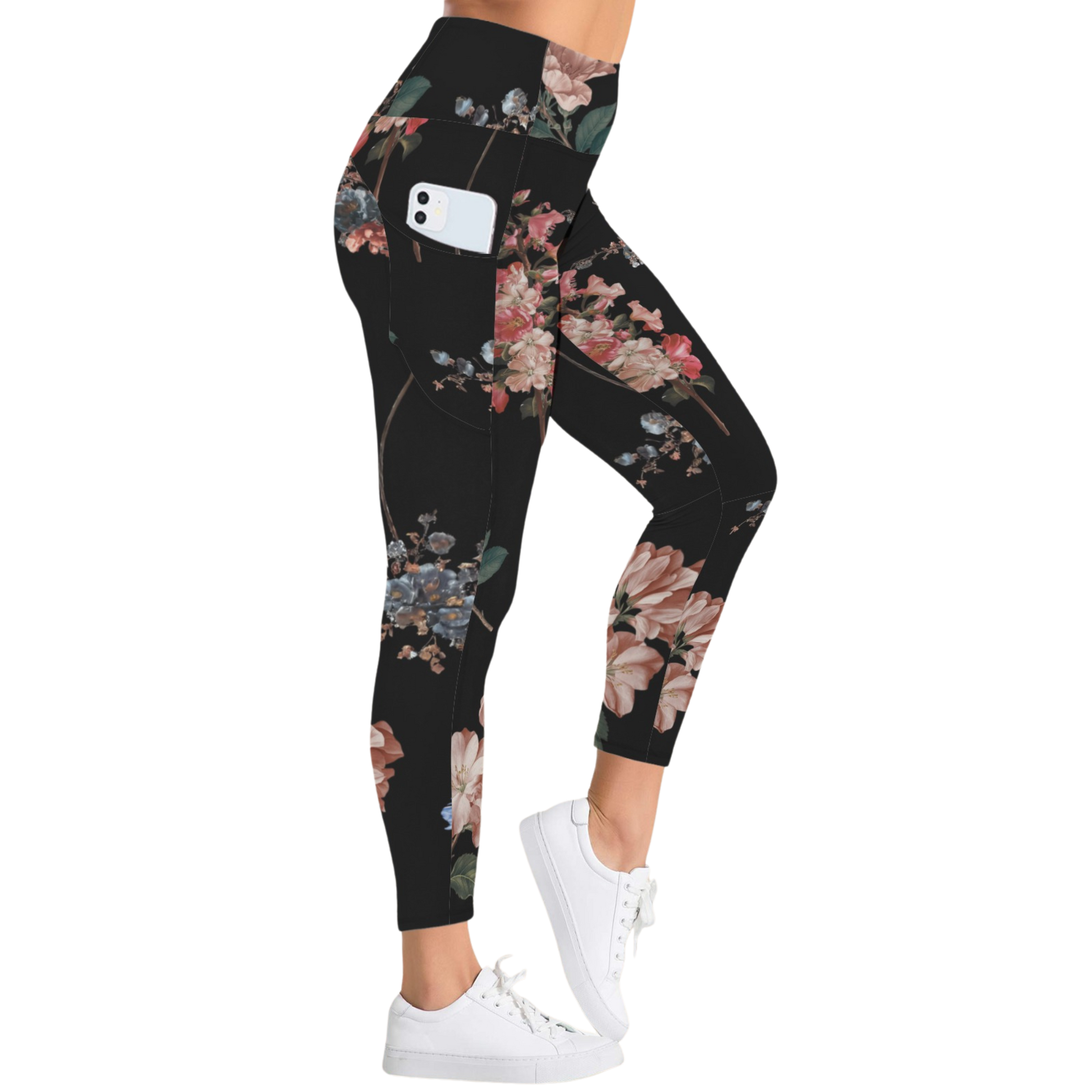 High-rise black leggings with colorful floral print, featuring side pockets and worn with white sneakers.